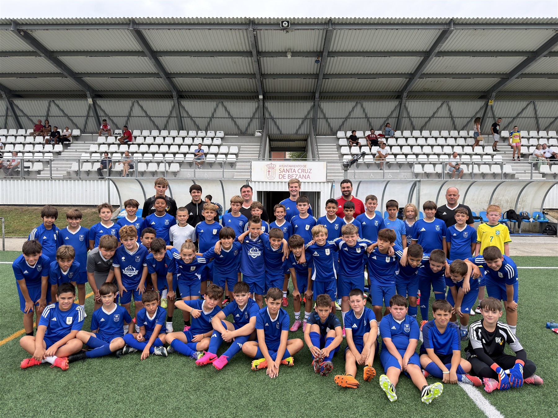 Jugadores y entrenadores del Marina Sport en las gradas del campo
